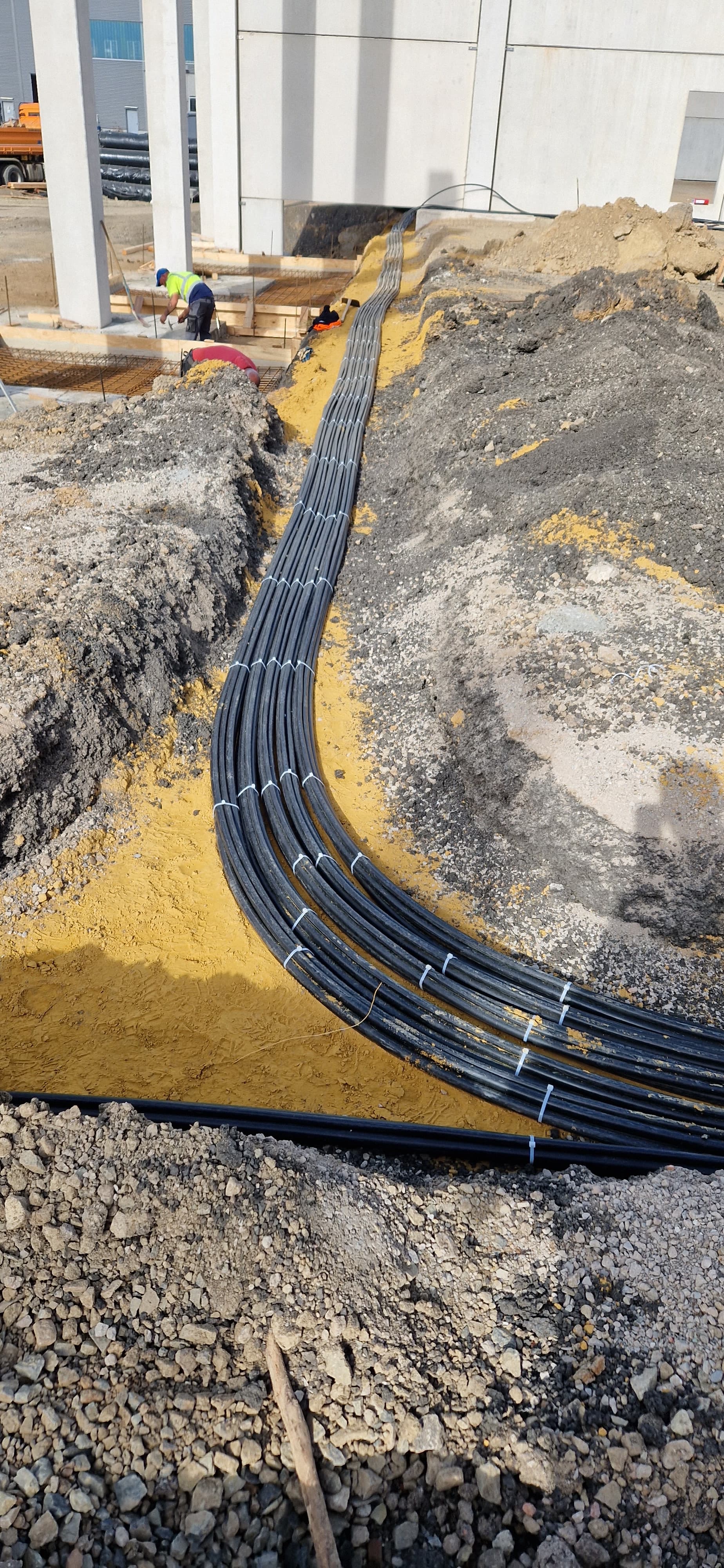 Gebündelte Starkstromkabel in einem Kabelgraben auf einer Industriebaustelle