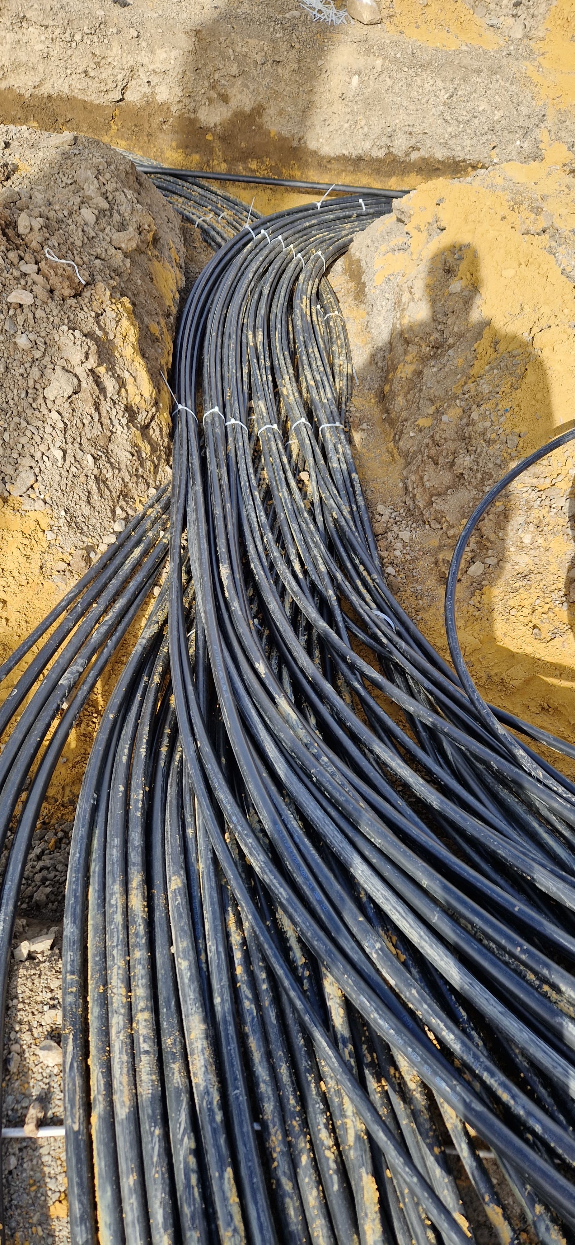 Mehrere Stromkabel werden durch eine Wanddurchführung in ein Industriegebäude geführt