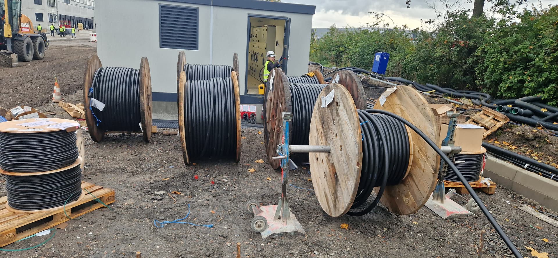 Verlegte Industriekabel neben einem Fundament einer Industriehalle