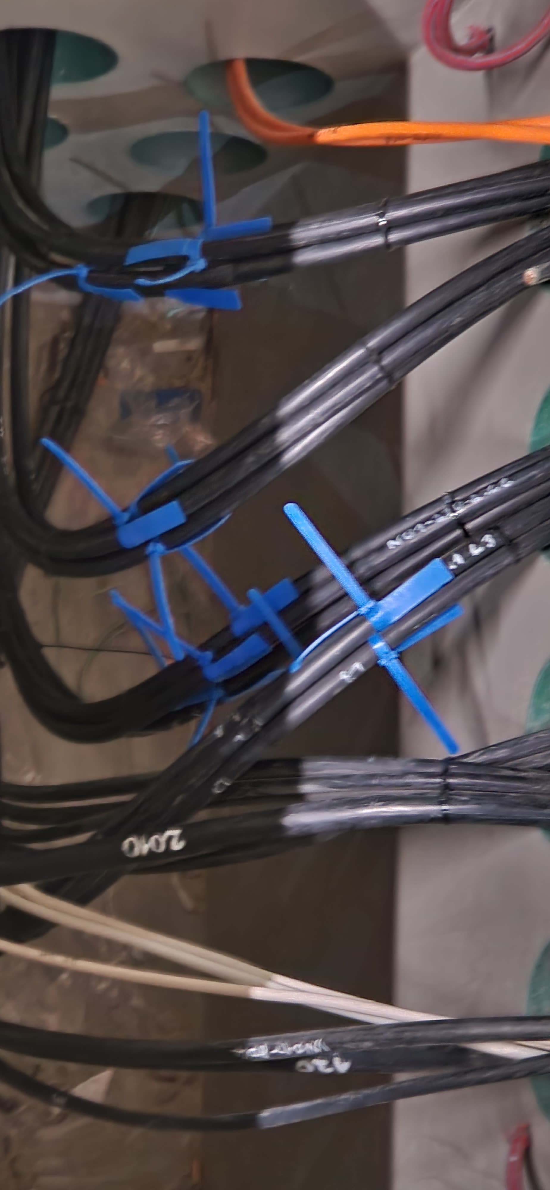 Monteur installiert Stromkabel in einer vertikalen Kabeltrasse