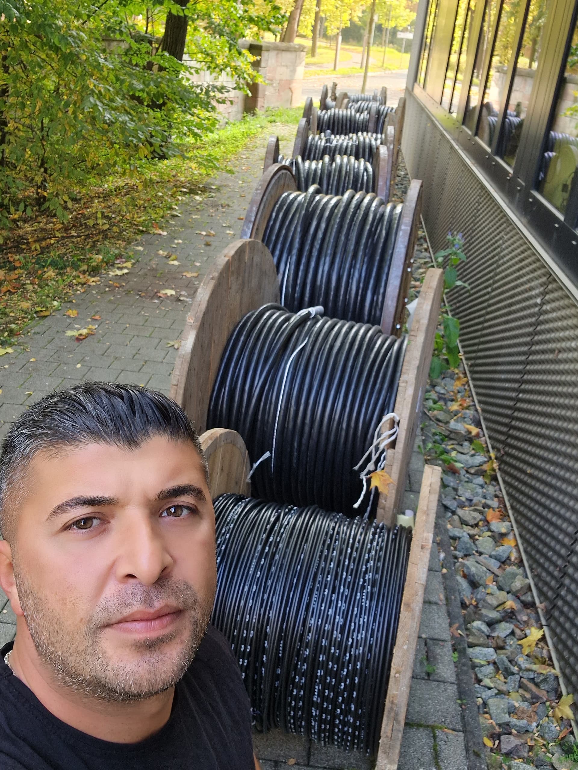 Vertikale Kabeltrasse mit Industriekabeln an einer Gebäudewand