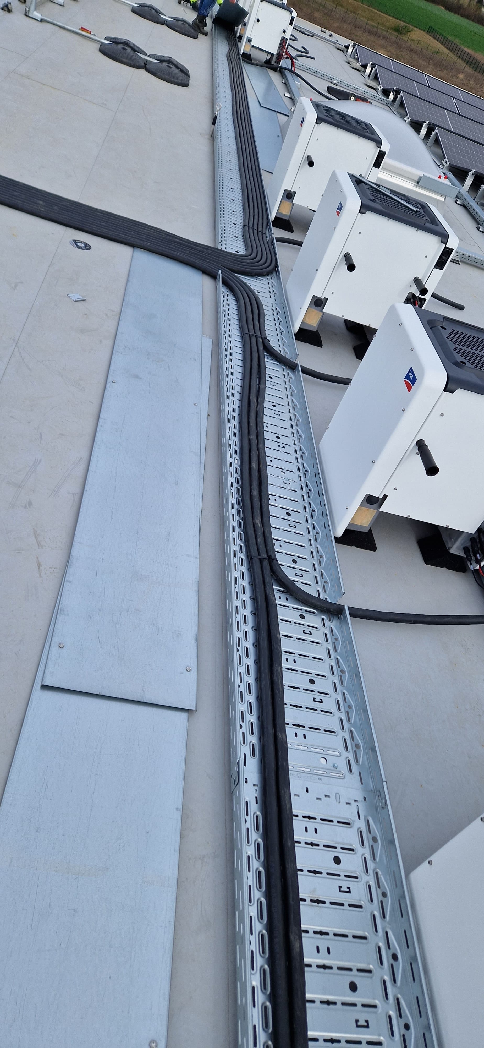 Große Industriekabel verlaufen durch Wanddurchführungen zu Schaltschränken